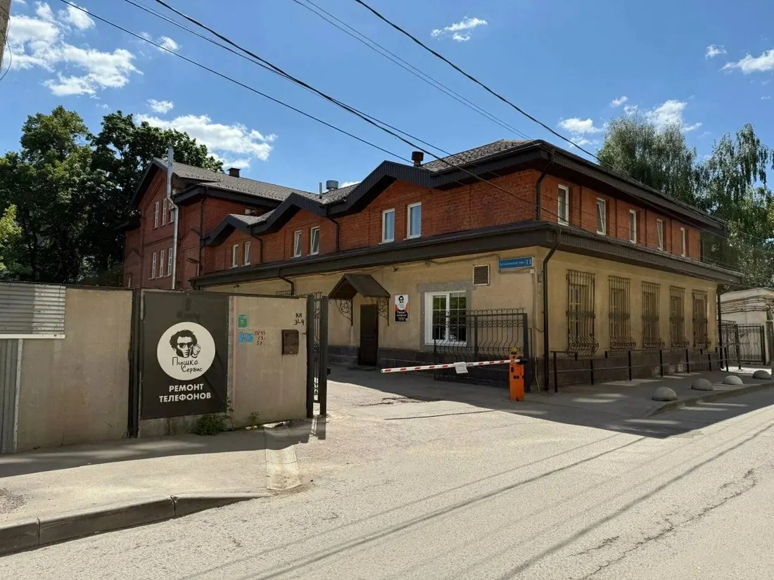 Вход в Пушка Сервис: дверь под козырьком, рядом табличка с логотипом